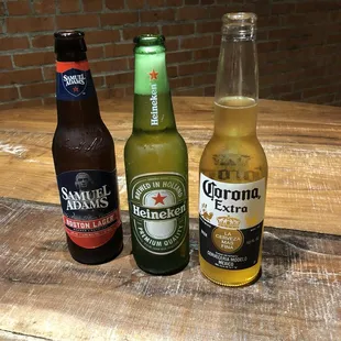 three bottles of corona beer on a wooden table