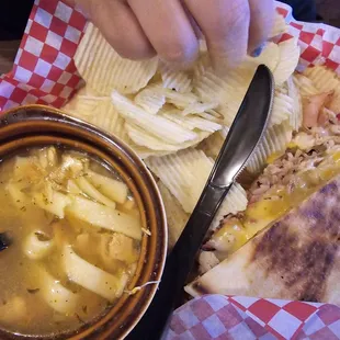 Rio Grande sandwich with chicken noodle soup and chips. The sandwich has pastrami, turkey, ham, green chile