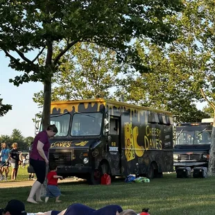 people laying on the grass in front of a food truck