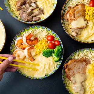 a person holding chopsticks over a bowl of noodles