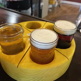 three jars of beer on a tray