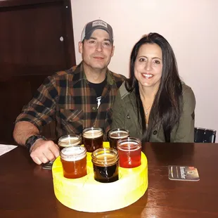 Customers enjoying THE BIG CHEEZ flight of beers served in a cheez wheel.