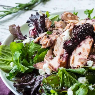 a plate of salad with meat and greens