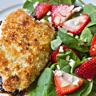 a plate of food with spinach and strawberries