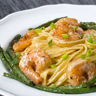 a plate of pasta with shrimp and asparagus