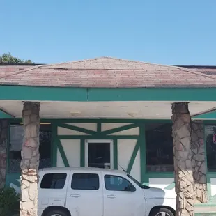 a white van parked in front of a restaurant