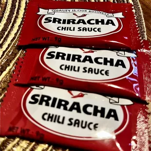 three packets of sricha chili sauce