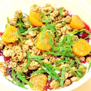 a plate of food with oranges and granola