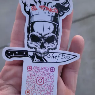a sticker of a skull holding a knife