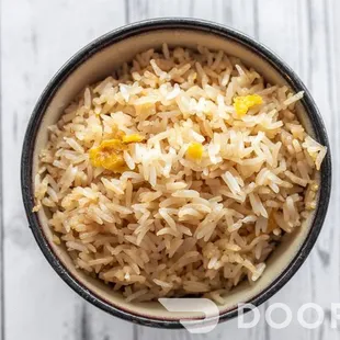 a bowl of brown rice on a wooden table