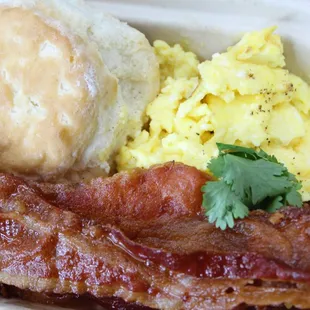 bacon, eggs, and biscuits in a styrofoam container