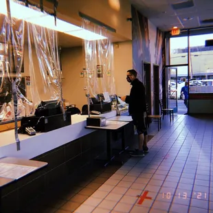 a man standing at a counter in a restaurant