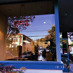 the reflection of a restaurant sign in the window