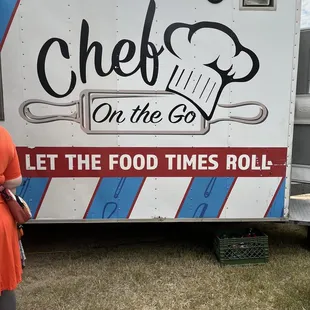 a woman standing in front of a food truck