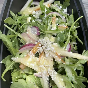 a salad in a black container