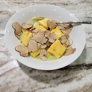 Three cheese gnocchi with pesto sauce and shaved black truffles