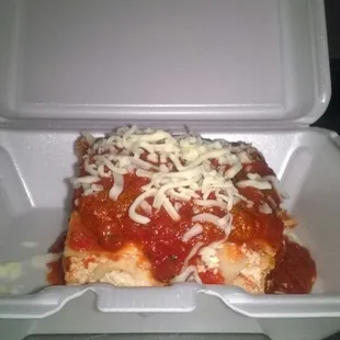 a slice of pizza in a styrofoam container