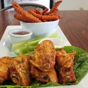 a plate of chicken wings and lettuce
