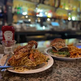 Blackened prawns, over garlic noodles, and a crabby patty a.k.a. surf &amp; turf burger with Creole fries!