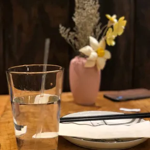 a glass of water and chopsticks