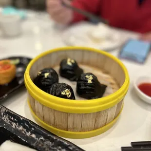 Squid ink shrimp dumpling with gold leaf
