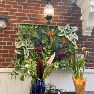 a brick wall with flowers in vases