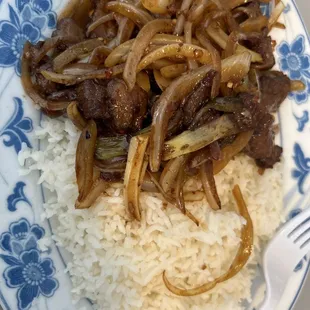 a plate of rice, beef and onions