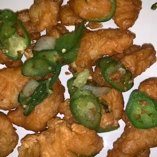 a plate of fried food with jalapenos
