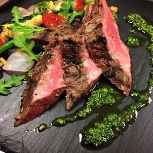 Marinated and grilled flank steak, served over a salad of seasonal vegetables, accompanied by a traditional Argentinian chimichurri