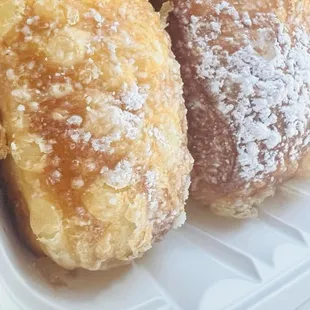 three pastries in a styrofoam container