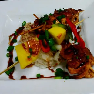 Jerk chicken kabobs over a bed of rice