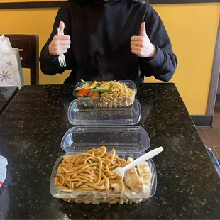 A satisfied customer with her chow mein, shrimp, and potstickers.