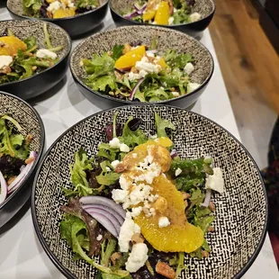 Cane Fields Salad - baby greens, red onion, feta cheese, orange supremes, toasted pecans, and our housemade Sugarcane Vinaigrette.