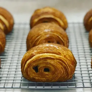 a row of croissants on a cooling rack