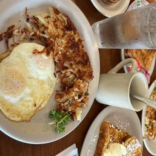 a breakfast of eggs, hash browns, french toast and waffles