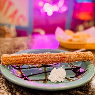 a plate of churros and whipped cream
