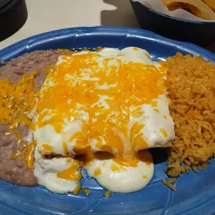 Delicious shredded chicken and cheese enchiladas w/ sour cream sauce! Beans and rice included. Yum!!