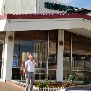 a man standing in front of a restaurant