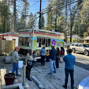 a group of people standing in front of a food truck