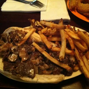 a steak sandwich with french fries