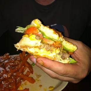 a hand holding a half eaten sandwich