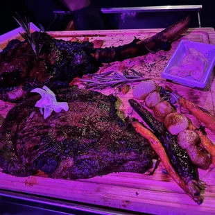 a steak and carrots on a cutting board