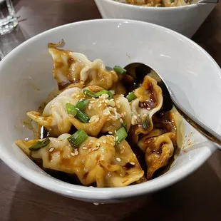 a bowl of dumplings and a spoon