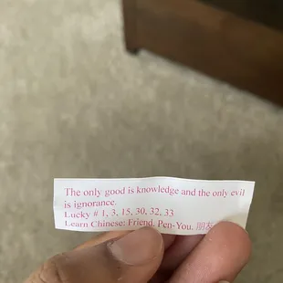 a hand holding a piece of paper with a poem written on it