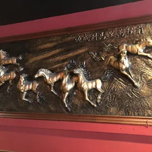a plaque of horses running