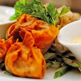 a plate of dumplings with dipping sauce
