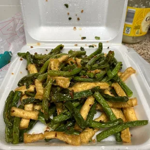 tofu and green beans in a styrofoam container