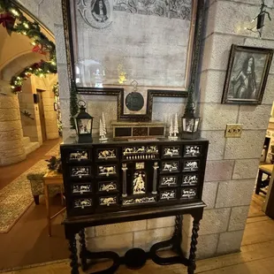 An ancient apothecary chest made of ebony with inlaid ivory. Above is the original pardon of King George II