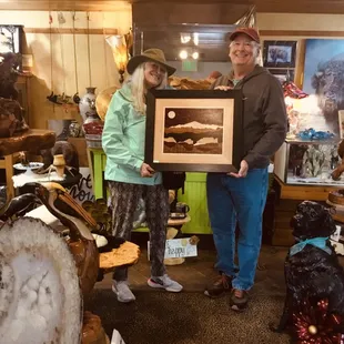 a man and a woman holding a framed picture