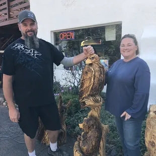 Happy customers on their way back to Texas with our Eagle and Bear carving by John Buzby.